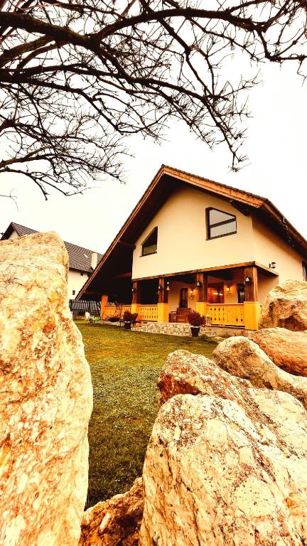 a house with two large rocks in front of it at Cuibul Braneanului in Bran