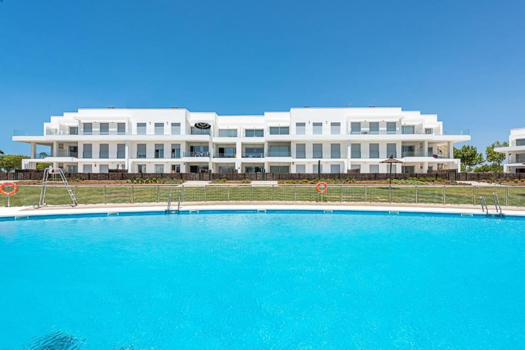 un gran edificio con una gran piscina frente a él en Costa Ballena - Playa Azul Beach House, en Costa Ballena