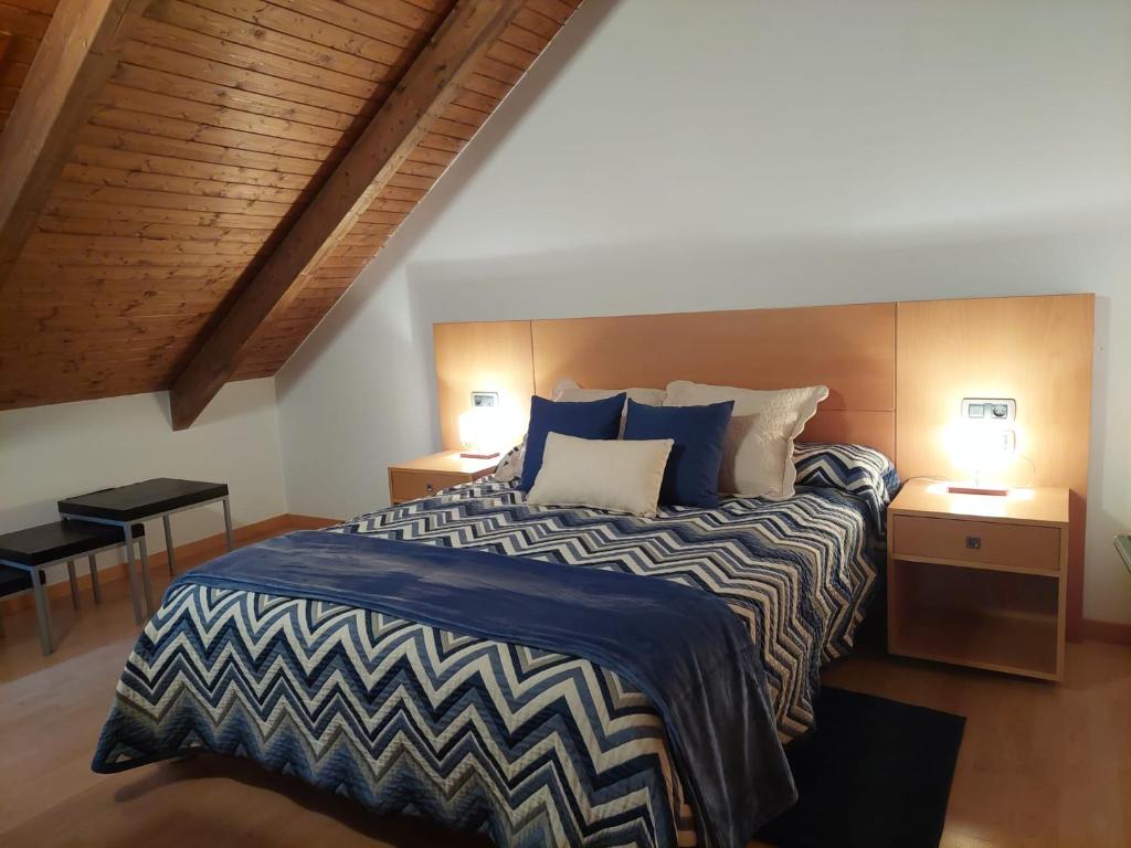 1 dormitorio con 1 cama grande con sábanas azules y blancas en Dúplex València d'Àneu, en Valencia de Aneu