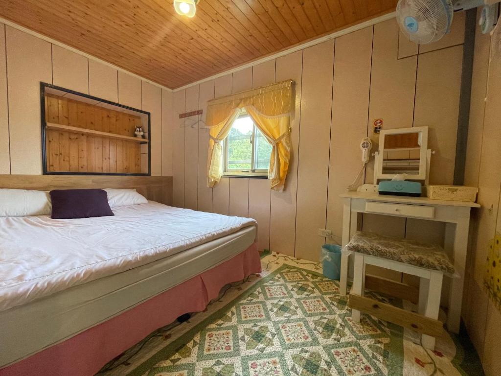 a small bedroom with a bed and a window at Linyuan Village in Jiufen