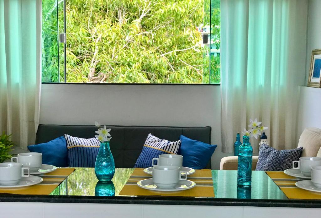 a dining room table with blue vases on it at Apartamento Excelente in Arraial do Cabo