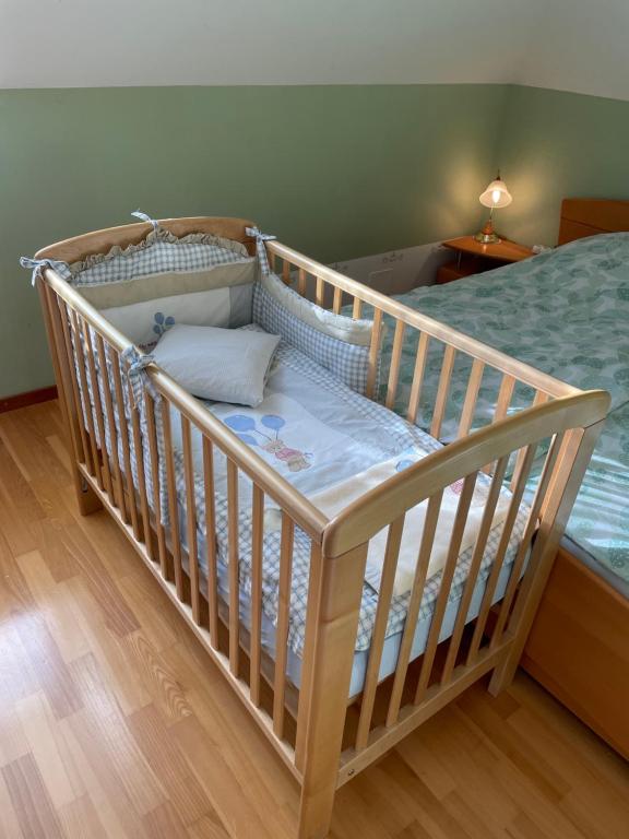 a baby crib in a room with a bed at Natasha's Garden House in Dol pri Ljubljani