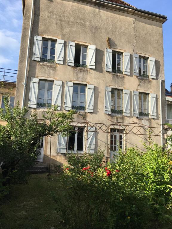 apartamentowiec z białymi oknami i krzakami w obiekcie Grand appartement tout confort en plein coeur d'Arbois w mieście Arbois