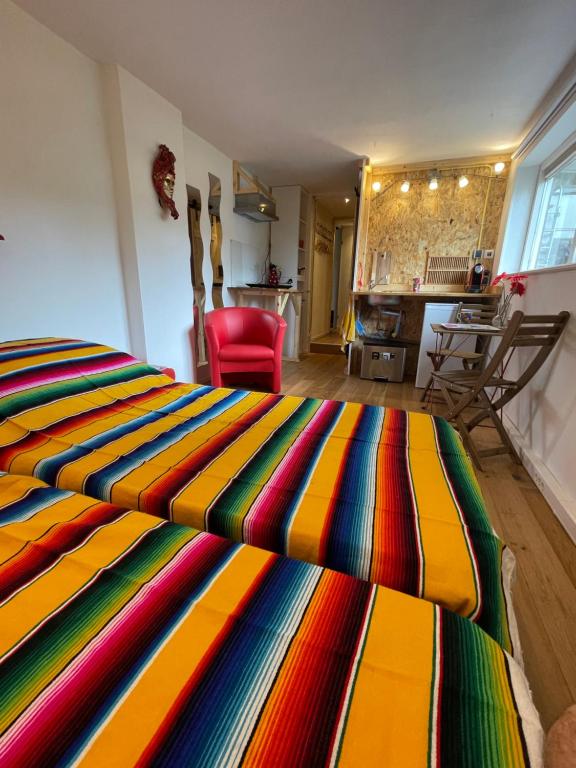 een kleurrijk gestreept bed in een kamer met een rode stoel bij Studio 7 in Hoogland