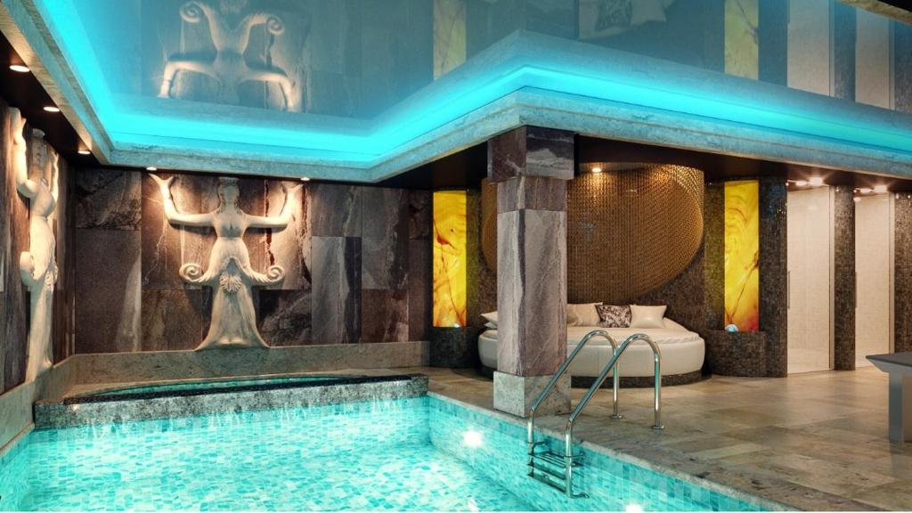 a swimming pool in a room with a tub at Tsarevets Design and Spa in Veliko Tŭrnovo