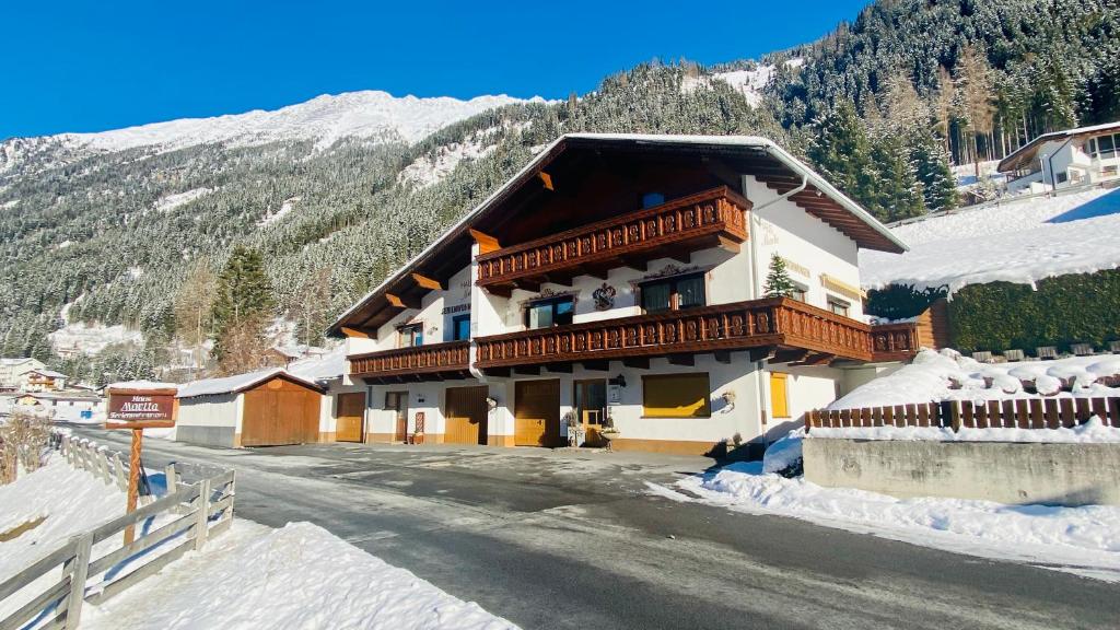 a building on a mountain with snow on the ground at Haus Marita in Sankt Leonhard im Pitztal