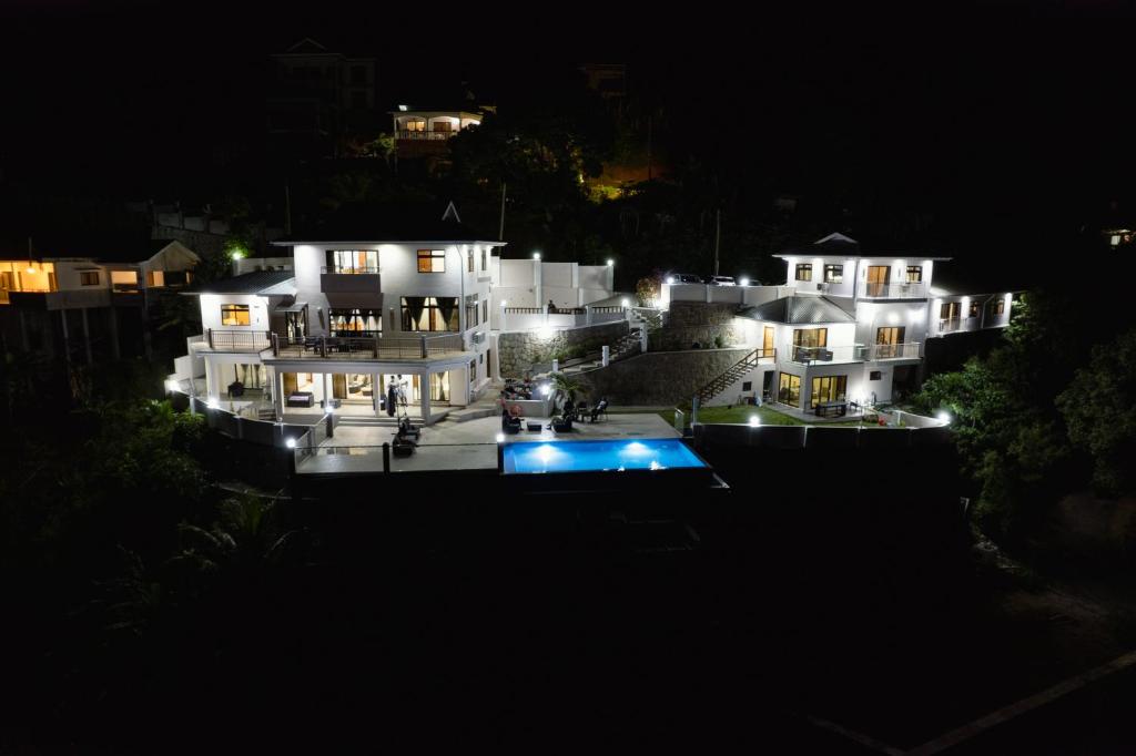 a night view of a large white house with lights at Maison L'Horizon in De Quincey Village