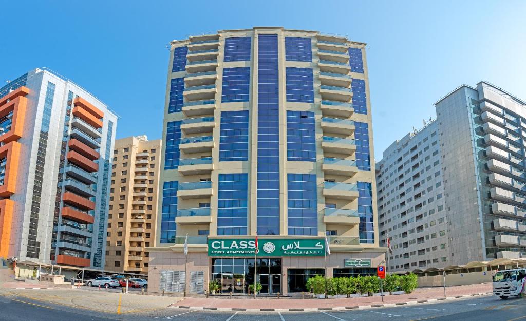 Class Hotel Apartments في دبي: مبنى طويل مع علامة أمامه
