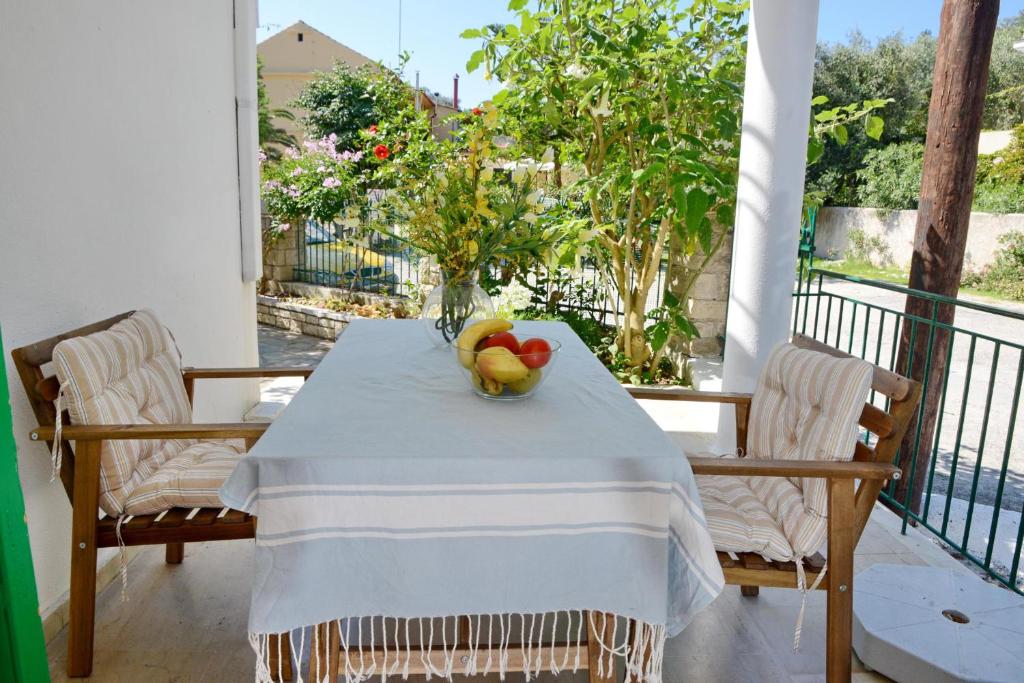 einen Tisch mit einer Obstschale auf dem Balkon in der Unterkunft Babis - LOGGOS APARTMENTS in Longós
