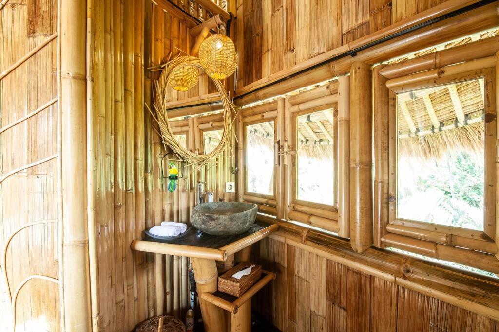 a bathroom with a sink in a wooden wall at Magic Hills Bali - Magical Eco-Luxury Lodge in Selat