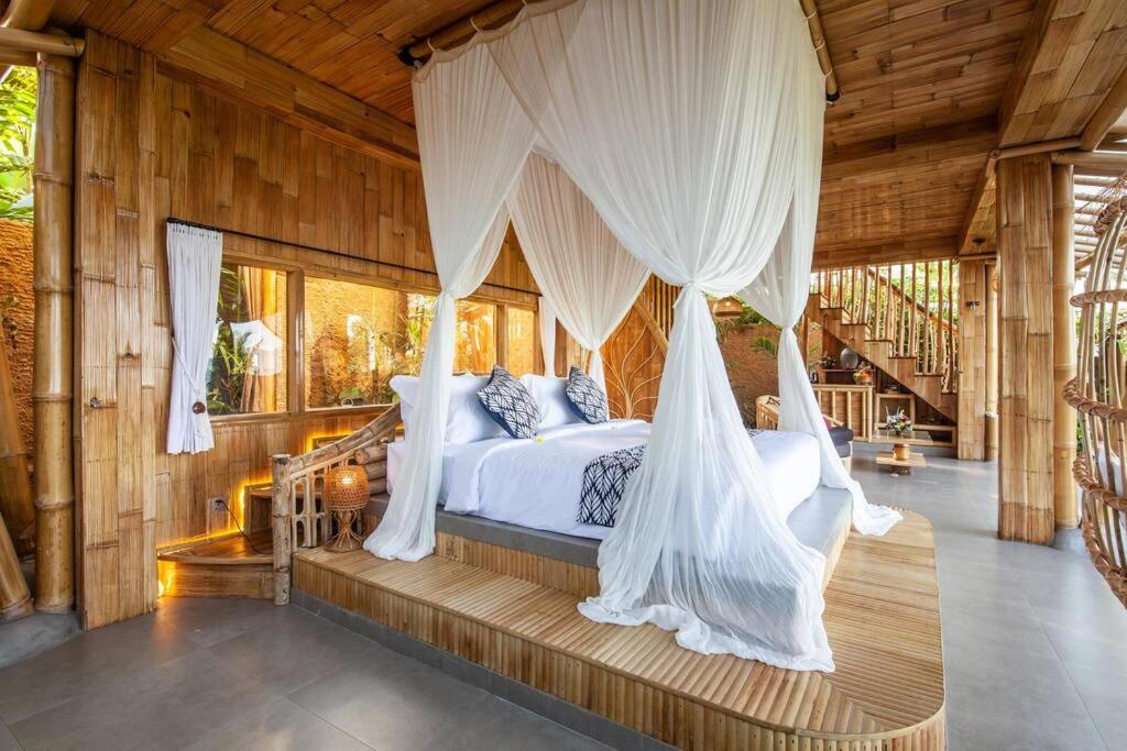 a bedroom with a bed with mosquito nets at Magic Hills Bali - Magical Eco-Luxury Lodge in Selat