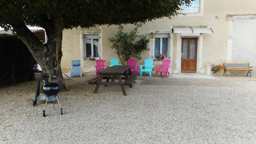 una mesa de picnic y sillas frente a una casa en Hébergement les cheminées, en Chemin