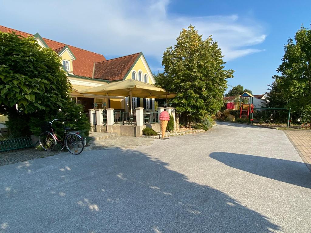 una casa con una bicicleta estacionada en la entrada en Landcafe Auszeit, en Albersdorf