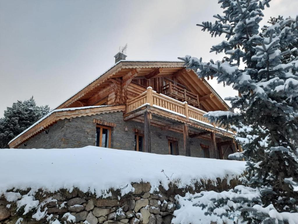 um chalé de madeira na neve com uma varanda em Chalet Sempre Més em Font Romeu Odeillo Via