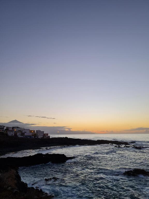 een zonsondergang boven de oceaan met rotsen in het water bij Apartamento La Barranquera in La Laguna