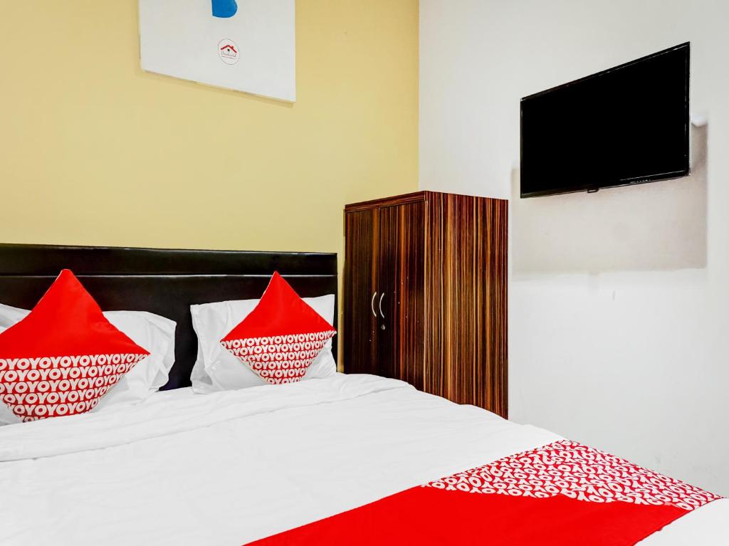 a bedroom with a bed with red pillows on it at Super OYO 90692 Point Hostel in Jakarta