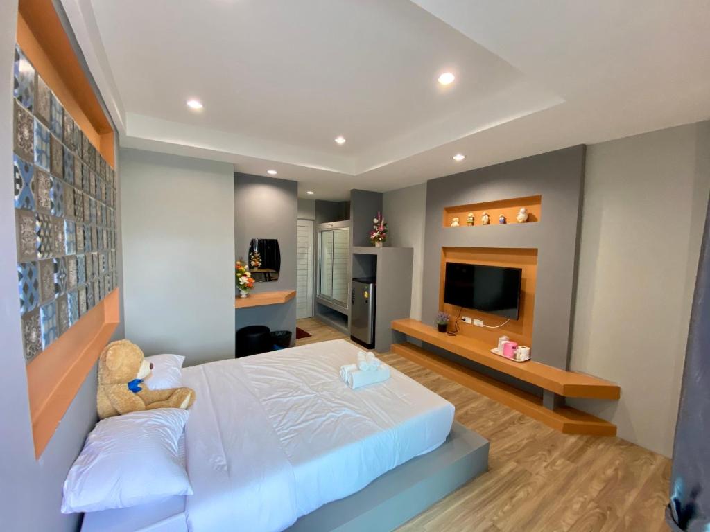 - une chambre avec un ours en peluche assis sur un lit dans l'établissement แองจี้รีสอร์ท@หทัยราษฎร์, à Ban Sai Mai