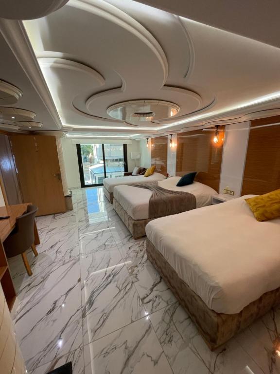 een hotelkamer met 3 bedden en een schuin plafond bij appart hotel puerto marino in Al Hoceïma