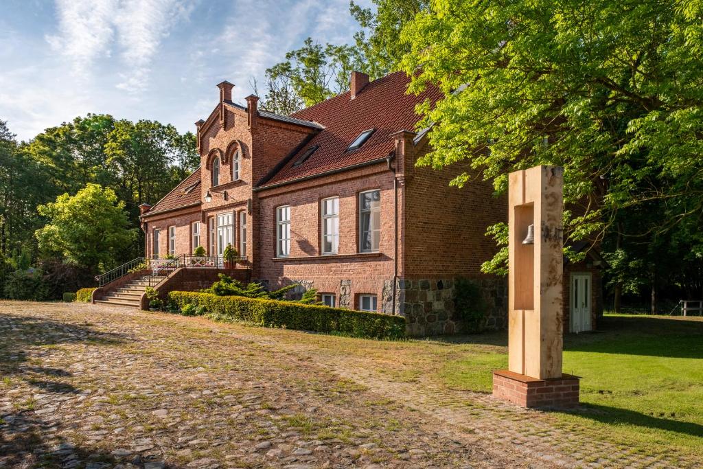 una gran casa de ladrillo con un árbol delante en Gutshof Falkenhagen, en Falkenhagen