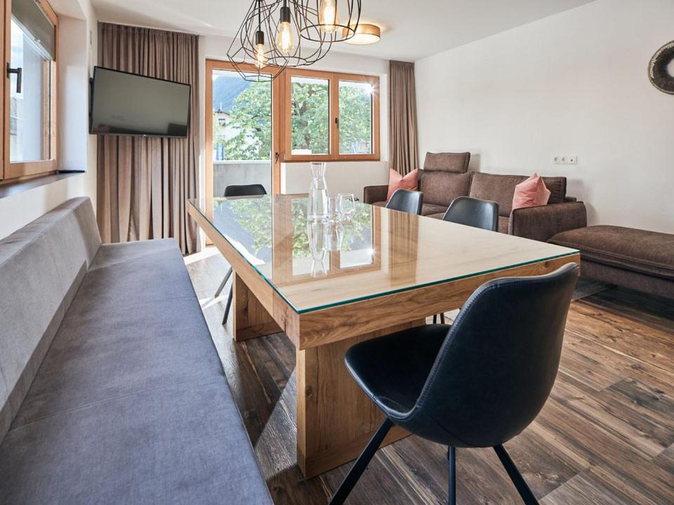 sala de estar con mesa y sofá en Alpenchalet S´Andalr, en Pfunds