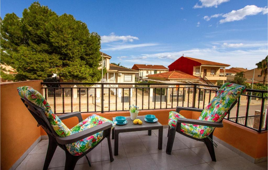 een patio met 2 stoelen en een tafel op een balkon bij Amazing Apartment In Los Narejos With Kitchen in Los Narejos