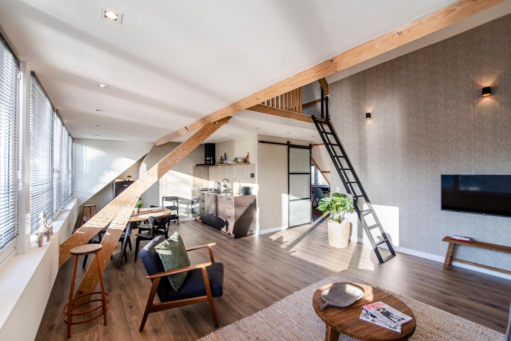 a living room with a staircase leading to a kitchen at Spacious Luxury Loft in Zandvoort