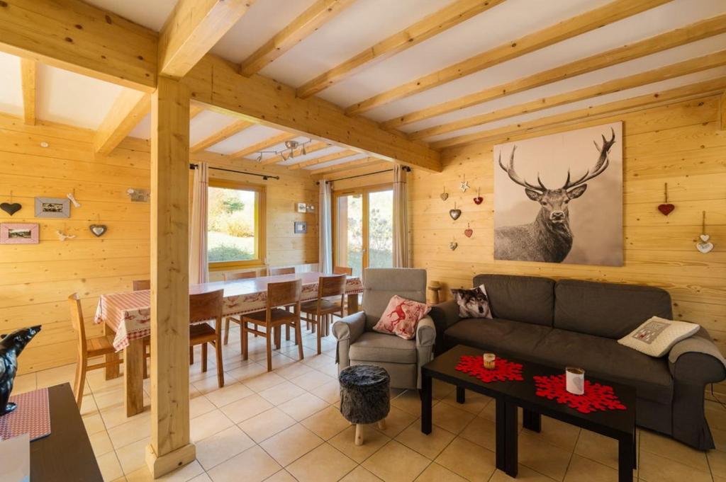 a log home living room with a table and a couch at Le Refuge du Cerf in Le Tholy