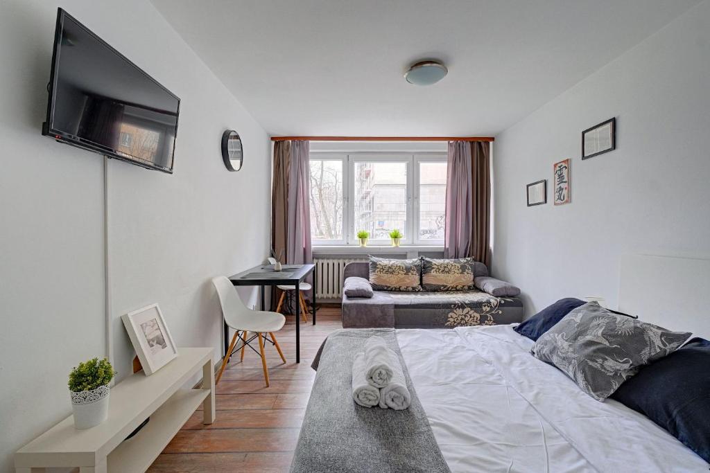 Un dormitorio con una cama y una sala de estar. en Noctis Apartment Bagno, en Varsovia