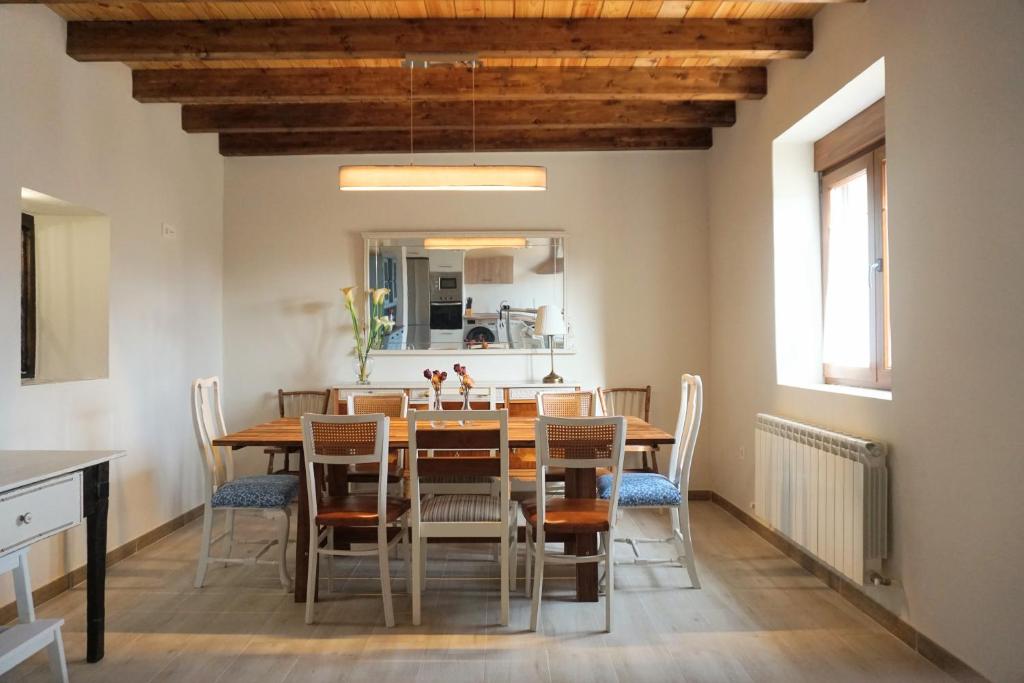 Casa Rural Las Cabañas de Castilla في Las Cabañas de Castilla: غرفة طعام مع طاولة وكراسي خشبية