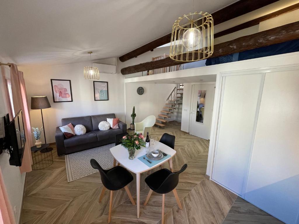 un soggiorno con divano, tavolo e sedie di Nice Renting - MASSENA - LOFT - HEART of VIEIL ANTIBES - THE MARKET WITH SEA VIEW a Antibes