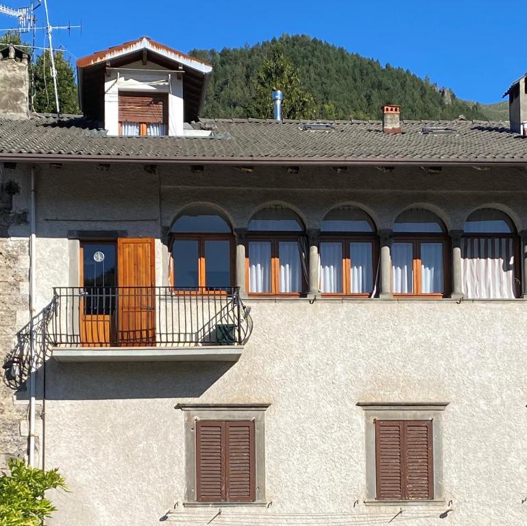 a building with brown doors and a balcony at Casa dell'alpinista in Castione della Presolana