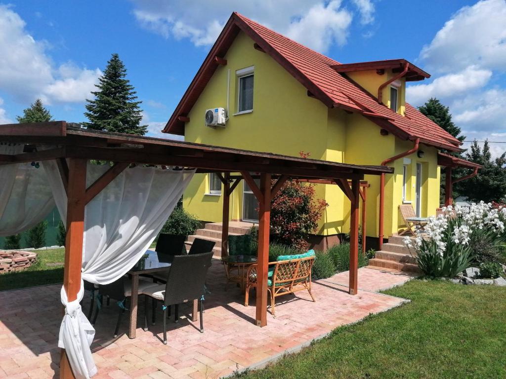 a yellow house with a wooden roof and a patio at Éva Háza Nyugalom/Pihenés/Relax in Sopron