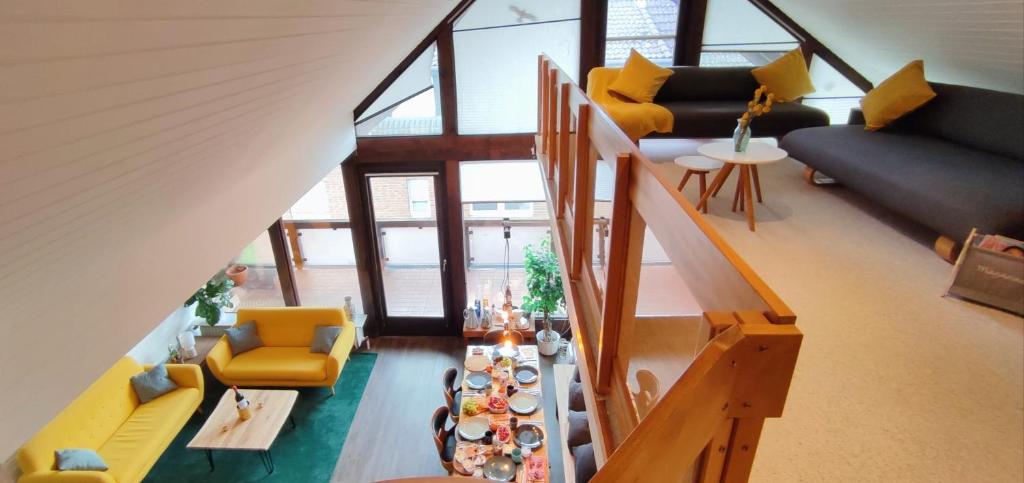 sala de estar con sillas amarillas y mesa en Stilvolle Galeriewohnung im Land der tausend Berge, en Marsberg