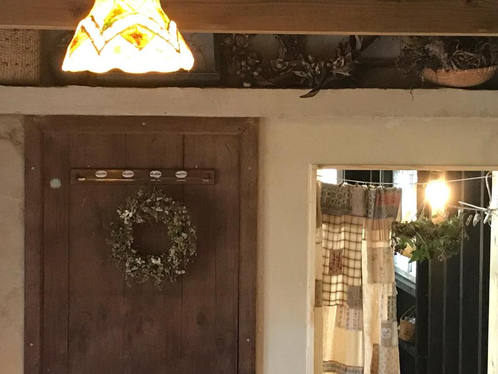 a door with a wreath and a light above it at Travelers House おーさんてぃん青空舎 in Taketomi