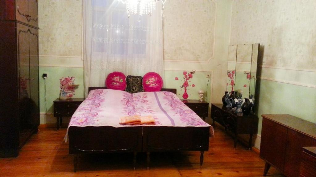 1 dormitorio con 1 cama grande con almohadas rosas en House in Ganja, en Ganja