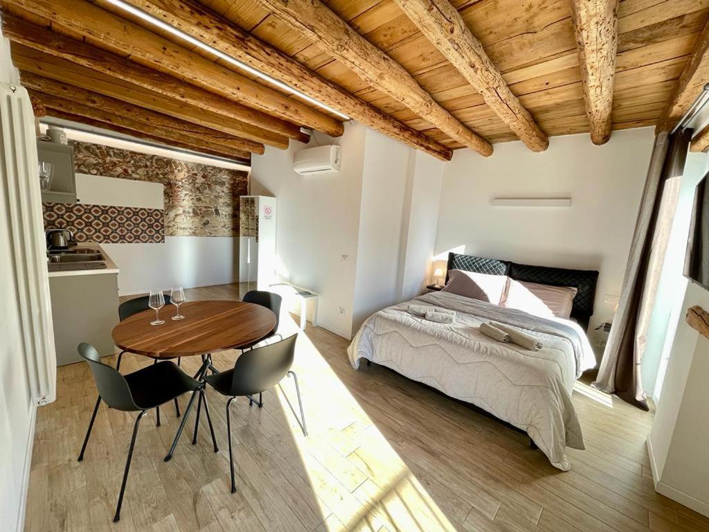 sypialnia z łóżkiem, stołem i krzesłami w obiekcie UnicumHouse Verona w Weronie