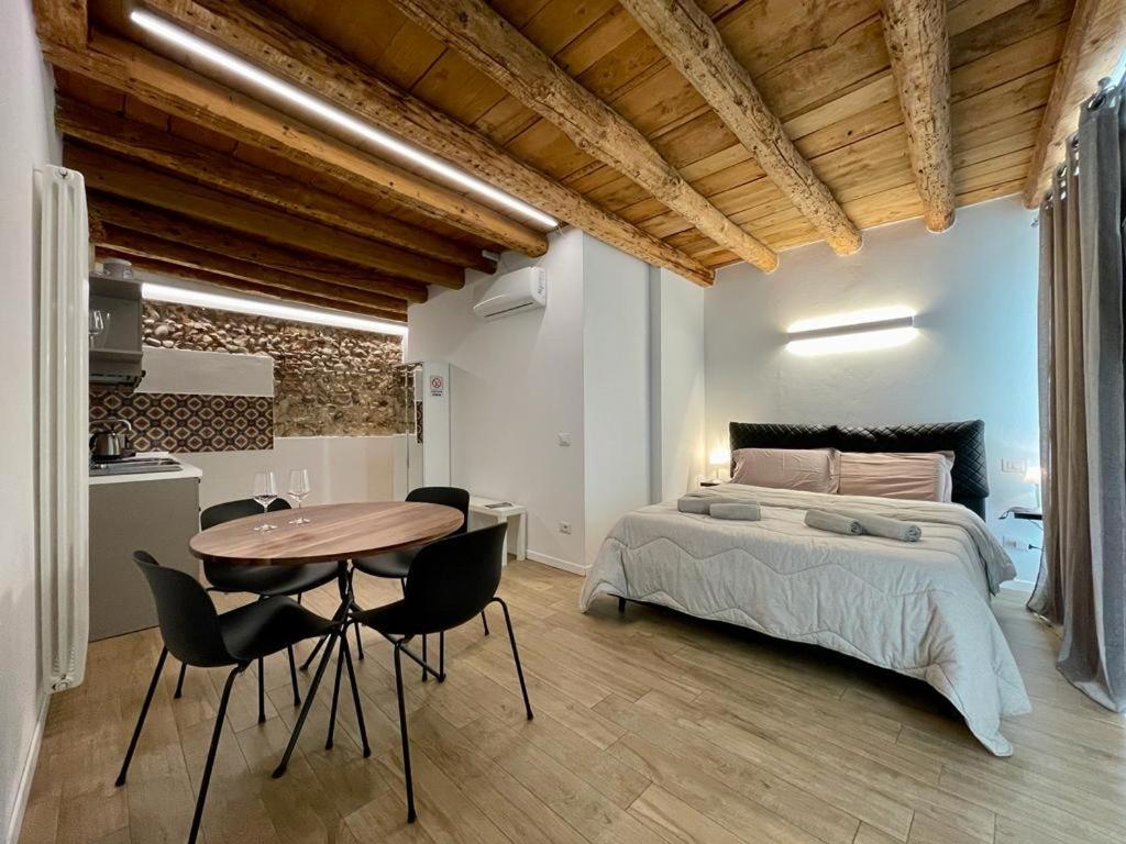 sypialnia z łóżkiem, stołem i krzesłami w obiekcie UnicumHouse Verona w Weronie