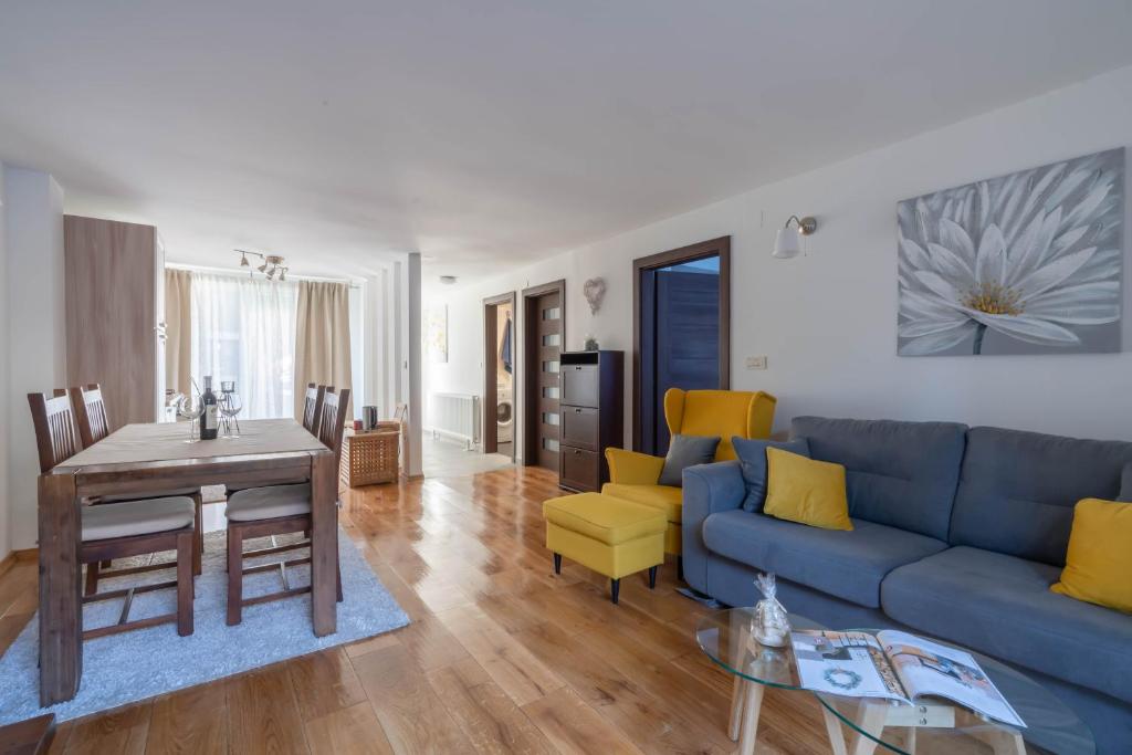 uma sala de estar com um sofá azul e cadeiras amarelas em Apartment Gabriella em Zagreb