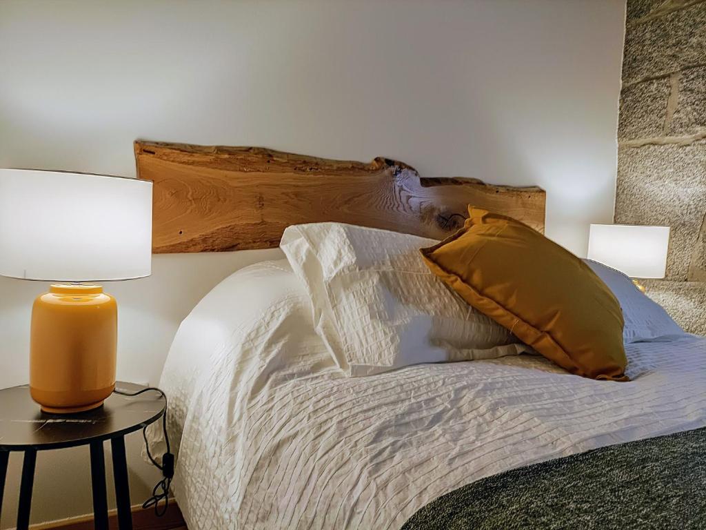 a bedroom with a bed with two lamps on a table at Casa Ribeiro in Sabugueiro