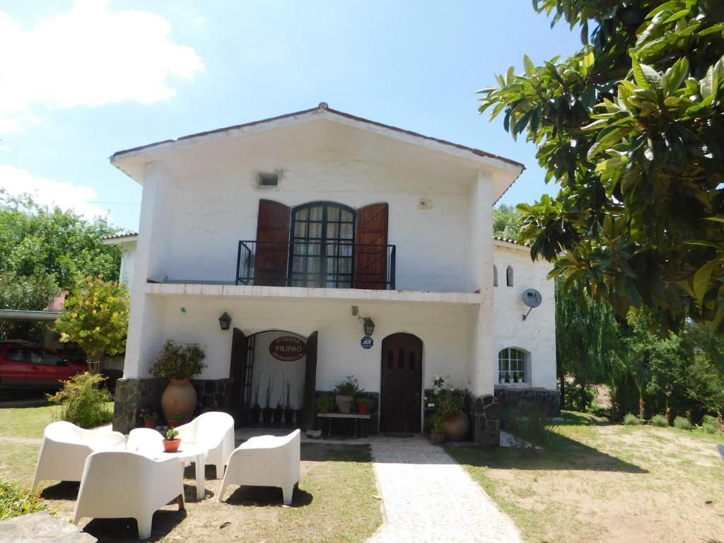 una casa blanca con muebles blancos delante en Filipao Aparts en Santa Rosa de Calamuchita