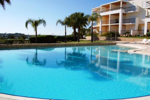 a large swimming pool in front of a building at Clube Alvor Ria in Alvor