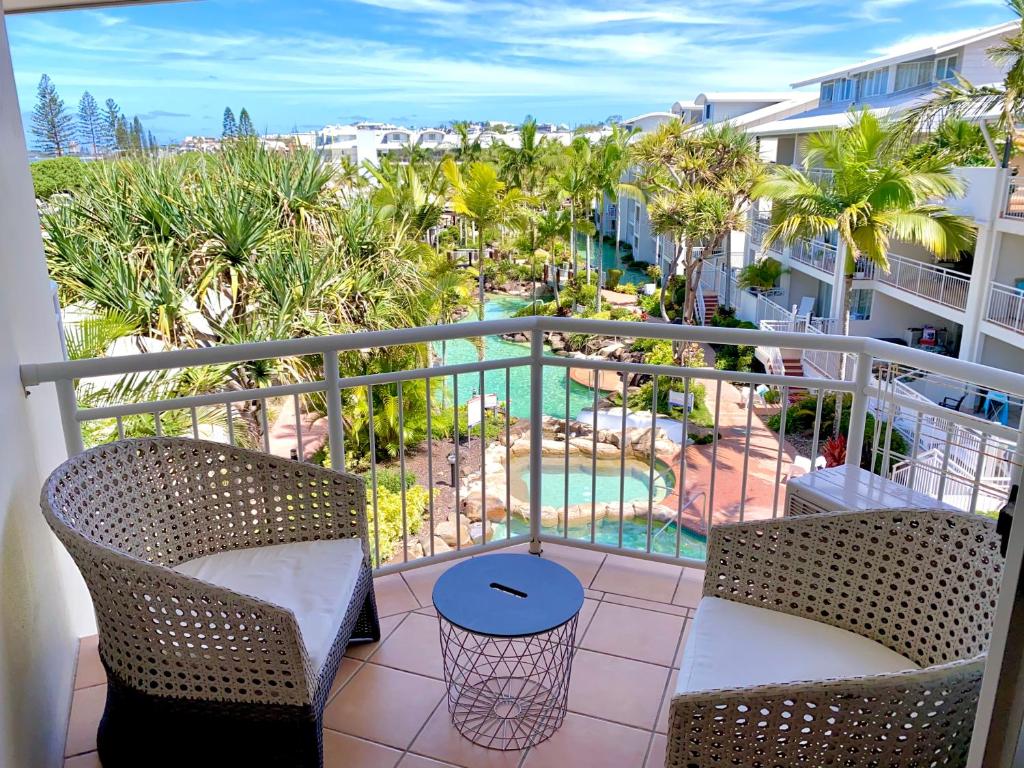 balcón con vistas a la piscina y a las palmeras en Resort Queen Studio at Alex Beach Resort, en Alexandra Headland