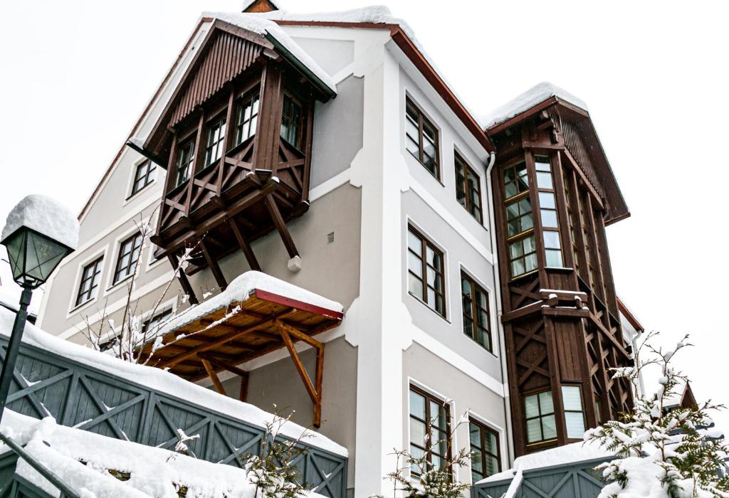ein Gebäude mit Schnee an den Fenstern und einem Straßenlicht in der Unterkunft VillaJazz Apartments in Murau