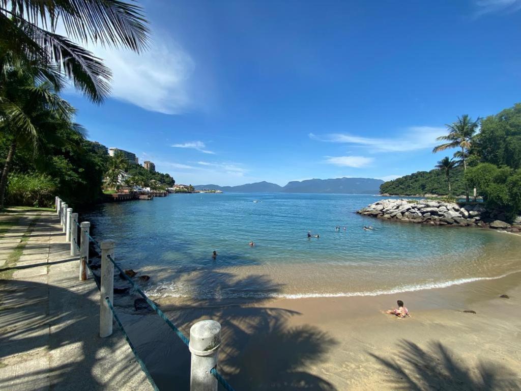 a beach with people swimming in the water at Porto Real Suites Mangaratiba in Mangaratiba