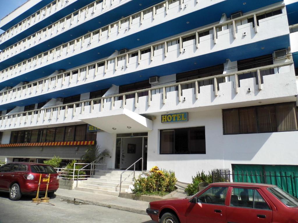 a red car parked in front of a cruise ship at Hotel Betoma in Santa Marta