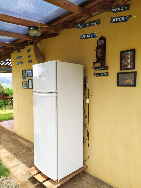 un frigorifero bianco seduto accanto a un muro di Aldeia Canastra Pousada a São Roque de Minas