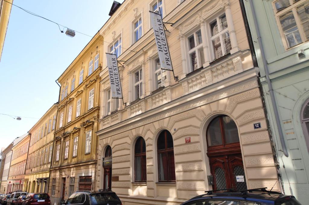 un bâtiment dans une rue avec des voitures garées devant elle dans l'établissement Hotel Prague Star, à Prague