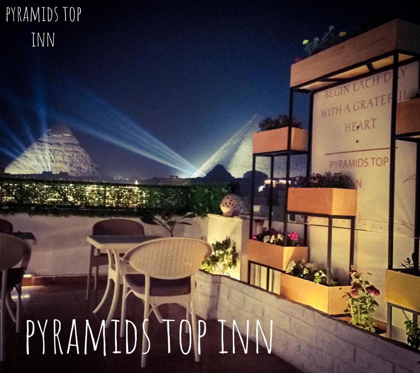 a balcony with a table and chairs at night at Pyramids Top Inn in Cairo