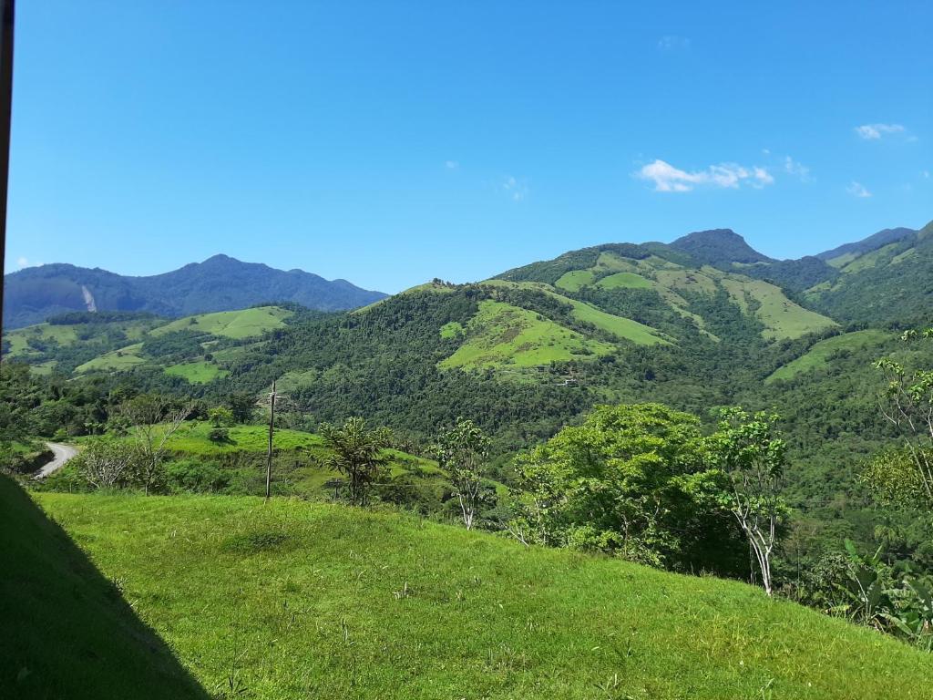 vista su una verde collina con montagne sullo sfondo di Pousada Vereda Tropical a Parati