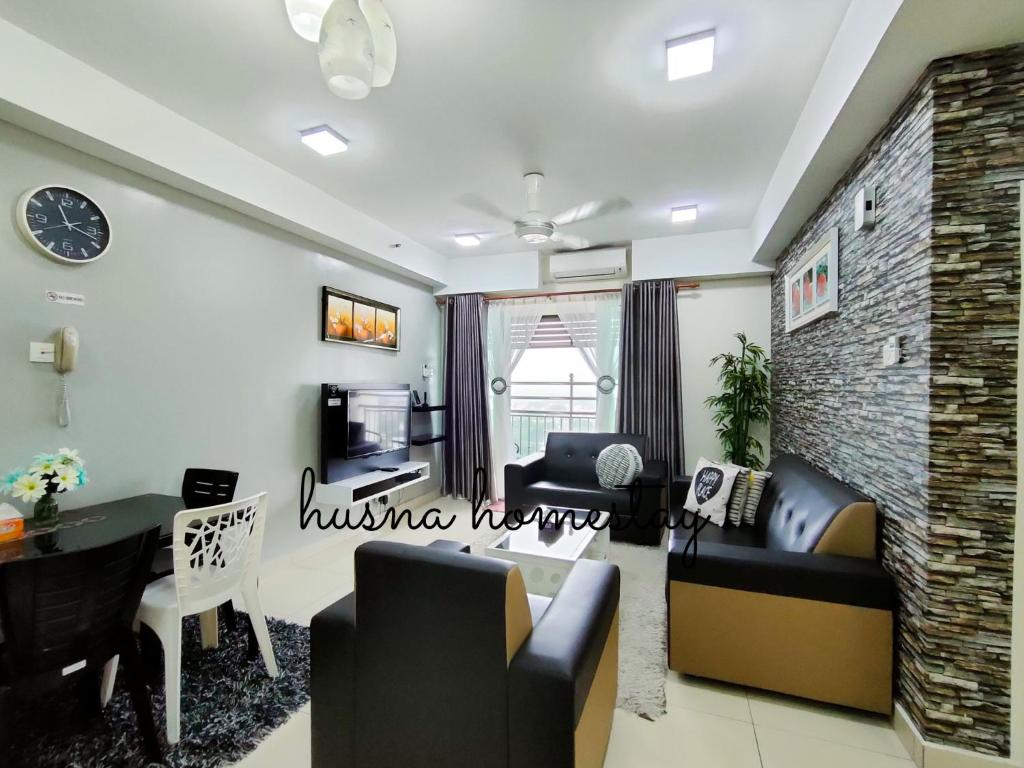 a living room with a couch and a dining room at Husna Apartment DPerdana Kota Bharu in Kota Bharu